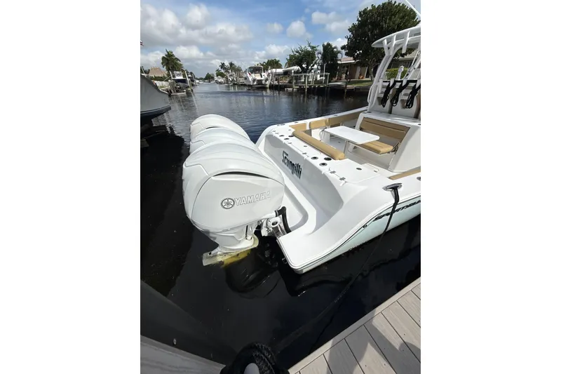 Slide: The Image of 2023 Sportsman Open 352 Center Console boat with Yamaha engines docked by the water. - 49