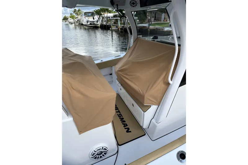 Slide: The Image of 2023 Sportsman Open 352 Center Console boat with covered seating, docked by the water. - 68
