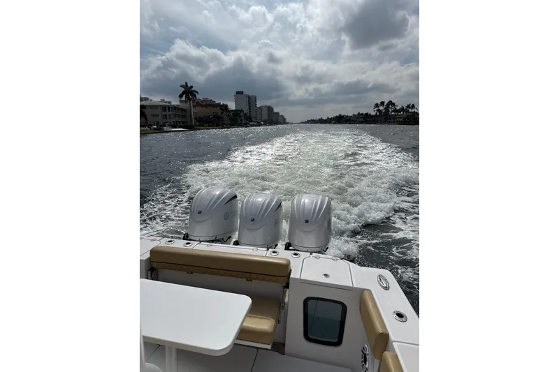 Slide: The Image of 2023 Sportsman Open 352 Center Console cruising on a waterway under cloudy skies. - 72