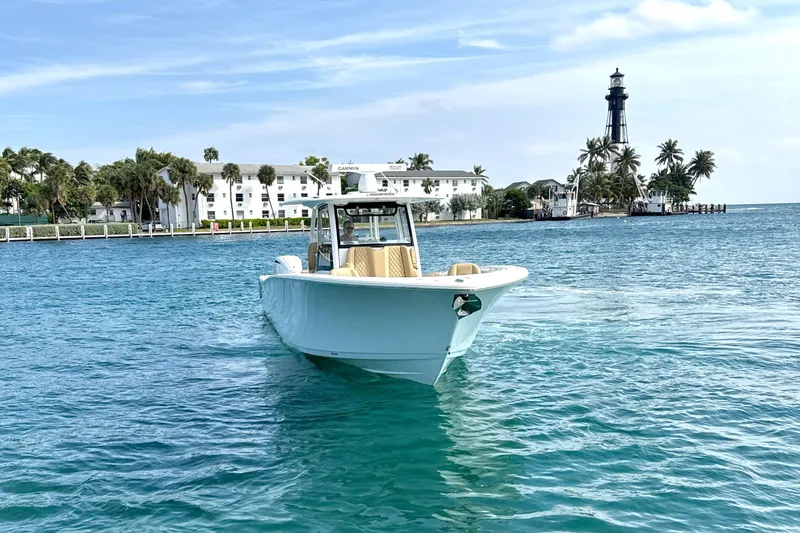Slide: The Image of 2023 Sportsman Open 352 Center Console boat on clear blue water near a lighthouse. - 75