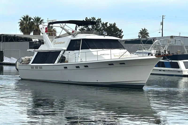 Slide: The Image of 1989 Bayliner 4588 Pilothouse yacht docked in marina, calm water, clear sky. - 2