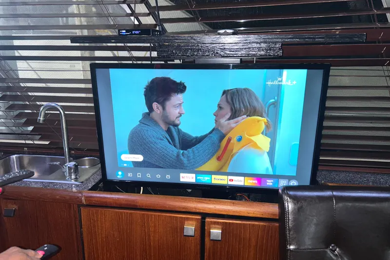 Slide: The Image of 1989 Bayliner 4588 Pilothouse interior with TV on a telescoping lift, wet bar beside. - 24