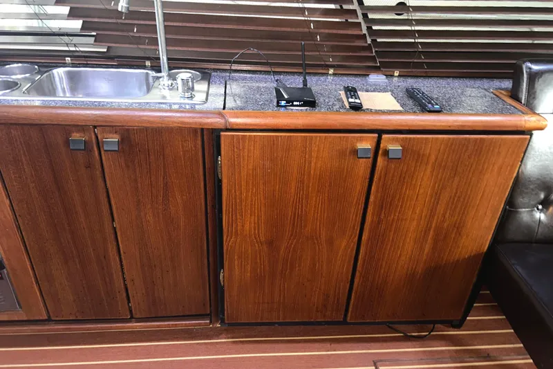 Slide: The Image of 1989 Bayliner 4588 Pilothouse interior with wooden cabinets and stainless steel sink. - 25