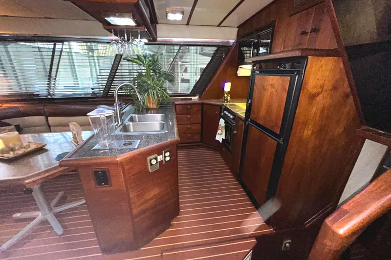 Slide: The Image of Luxurious 1989 Bayliner 4588 Pilothouse interior with wood finish and modern kitchen amenities. - 30