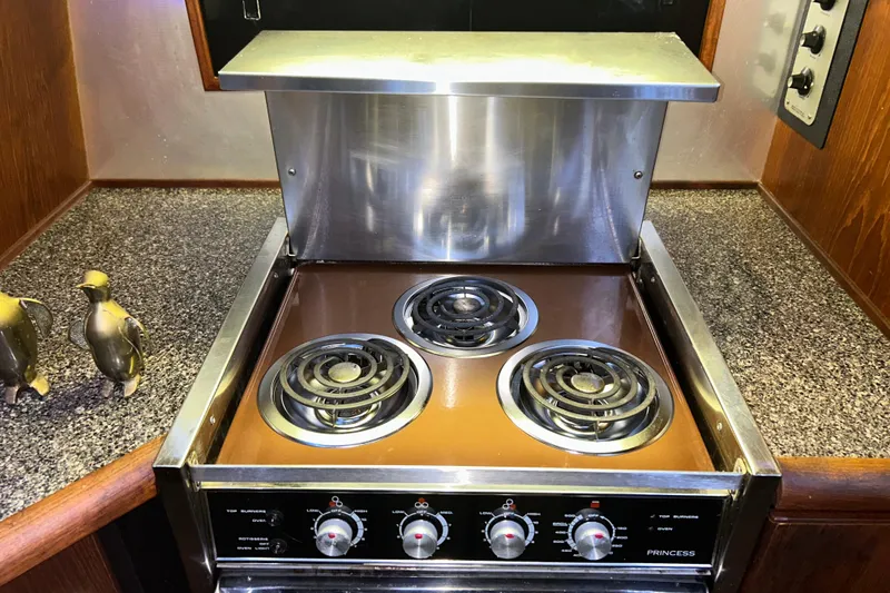 Slide: The Image of 1989 Bayliner 4588 Pilothouse kitchen with electric stove and metallic accents. - 35