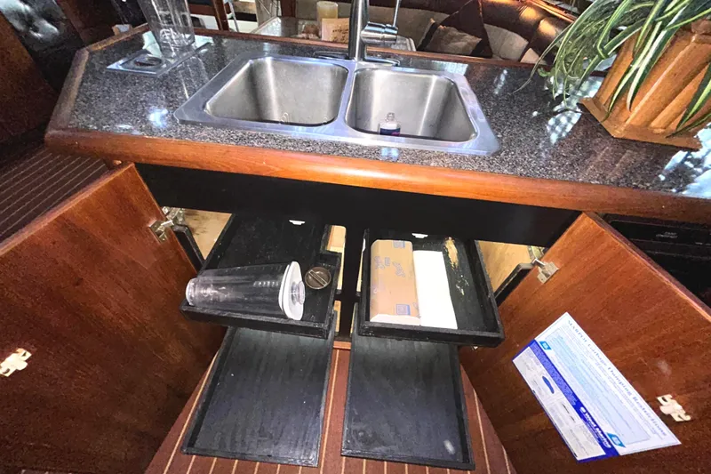 Slide: The Image of 1989 Bayliner 4588 Pilothouse galley with double sink and wooden cabinetry with pullout drawers - 37