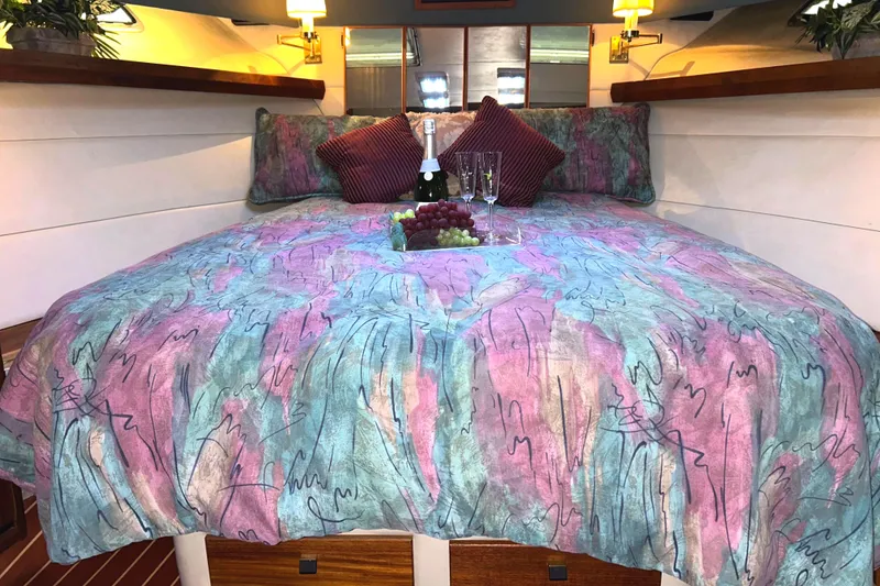 Slide: The Image of Luxurious cabin interior of 1989 Bayliner 4588 Pilothouse with colorful bedding and wine setup. - 40
