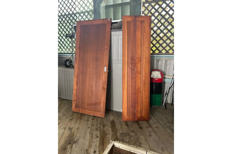 Slide: The Image of Wooden doors from a 1989 Bayliner 4588 Pilothouse, displayed on a wooden deck. - 50
