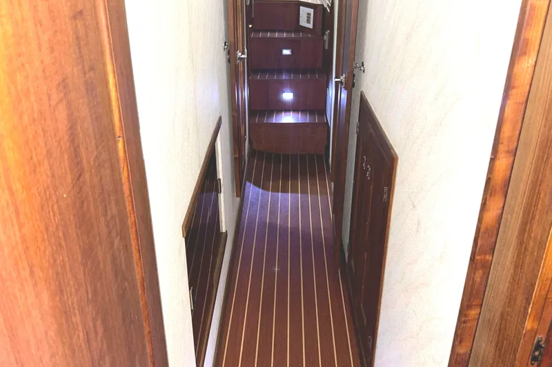 Slide: The Image of 1989 Bayliner 4588 Pilothouse interior hallway with wooden flooring and steps. - 54