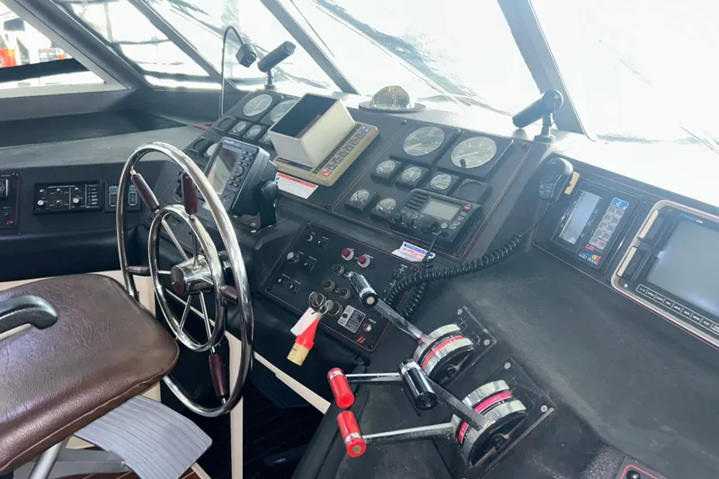 Slide: The Image of 1989 Bayliner 4588 Pilothouse helm with steering wheel and navigation instruments. - 63