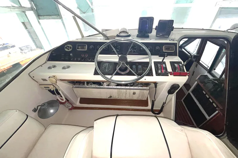 Slide: The Image of 1989 Bayliner 4588 Pilothouse helm with steering wheel and navigation instruments. - 74