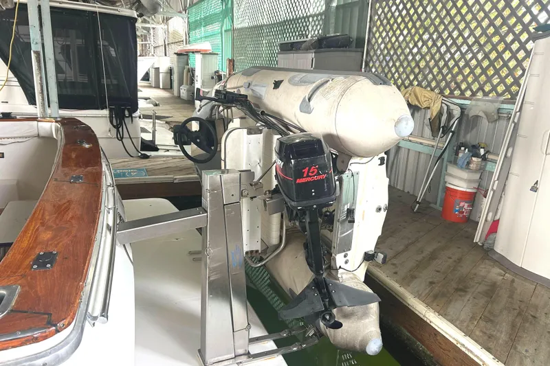 Slide: The Image of Dinghy on a Sea Wise davit system with Mercury 15 outboard motor in docked setting. - 84