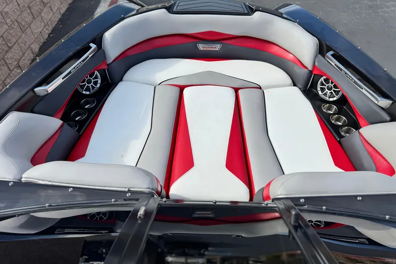 Slide: The Image of 2014 Supra SA350 boat interior with red and white seating, cup holders, and speakers. - 11