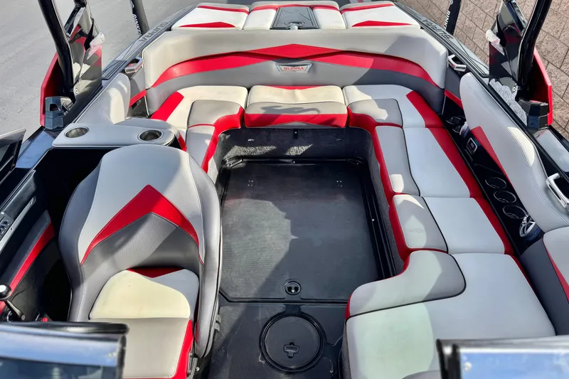 Slide: The Image of 2014 Supra SA350 boat interior with red and gray seating, cup holders, and spacious layout. - 18