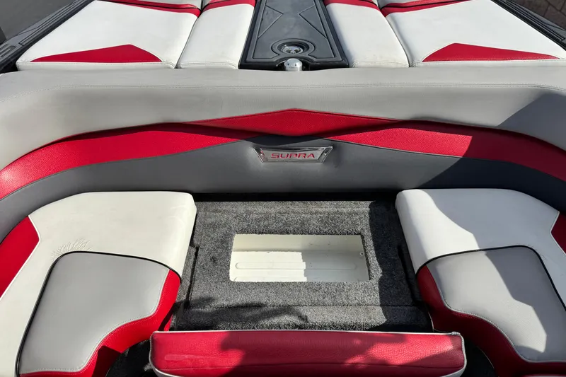 Slide: The Image of 2014 Supra SA350 boat interior with red and gray seating, showcasing stylish design. - 23