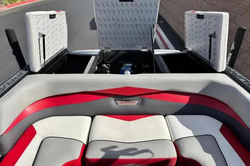 Slide: The Image of 2014 Supra SA350 boat interior with open storage compartments and red-gray seating. - 24