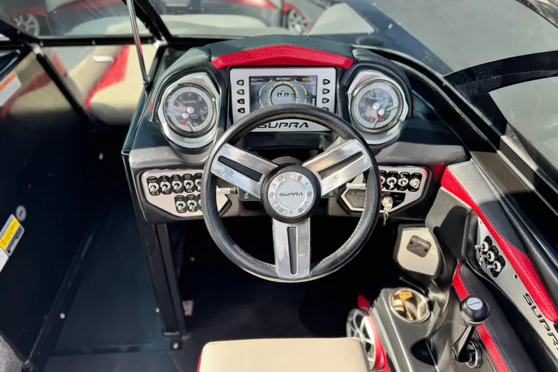 Slide: The Image of 2014 Supra SA350 boat dashboard with steering wheel and control panel. - 33