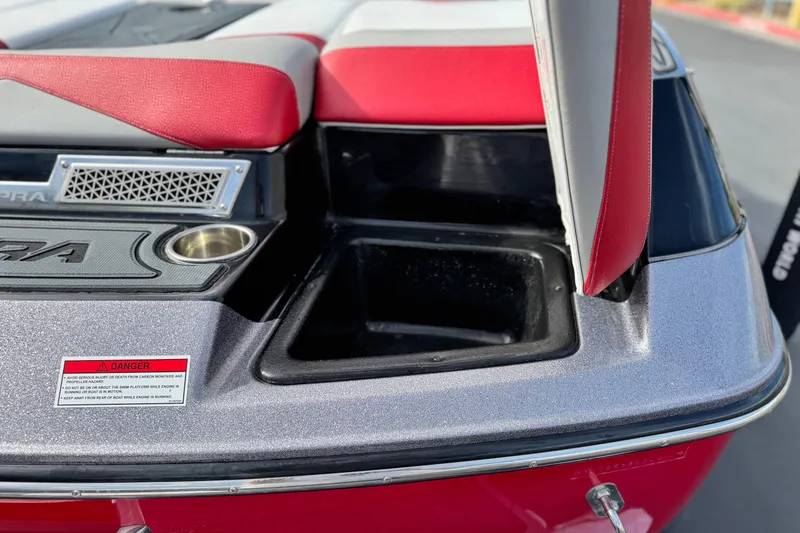 Slide: The Image of 2014 Supra SA350 boat interior with red and gray seating, cup holder, and safety warning label. - 7