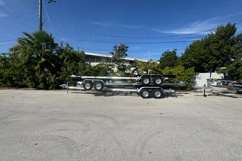Slide: The Image of 2025 Trailers Trailer Mania stacked in a parking lot under a clear blue sky. - 4