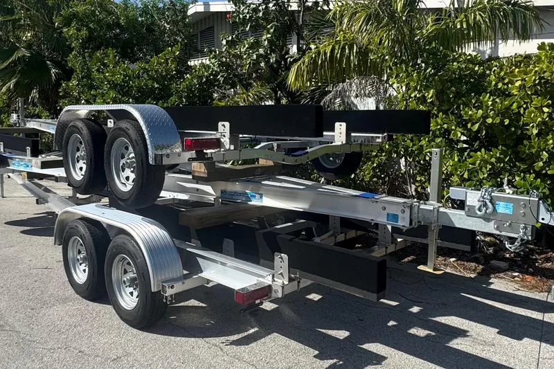 Slide: The Image of 2025 custom-built trailers stacked outdoors with lush greenery in the background. - 8