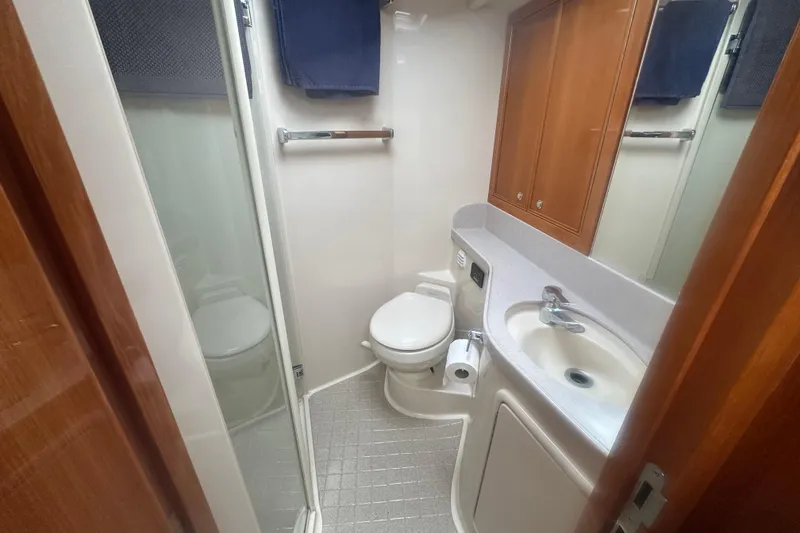 Slide: The Image of 2007 Riviera Sport Fisherman bathroom with shower, sink, and wooden cabinetry. - 12