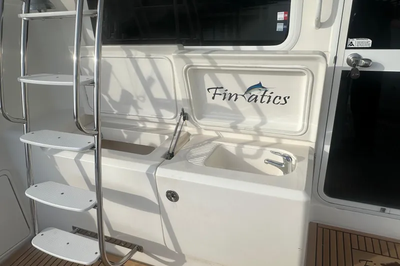 Slide: The Image of 2007 Riviera Sport Fisherman boat docked, featuring upper deck and ladder, under a partly cloudy sky. - 37