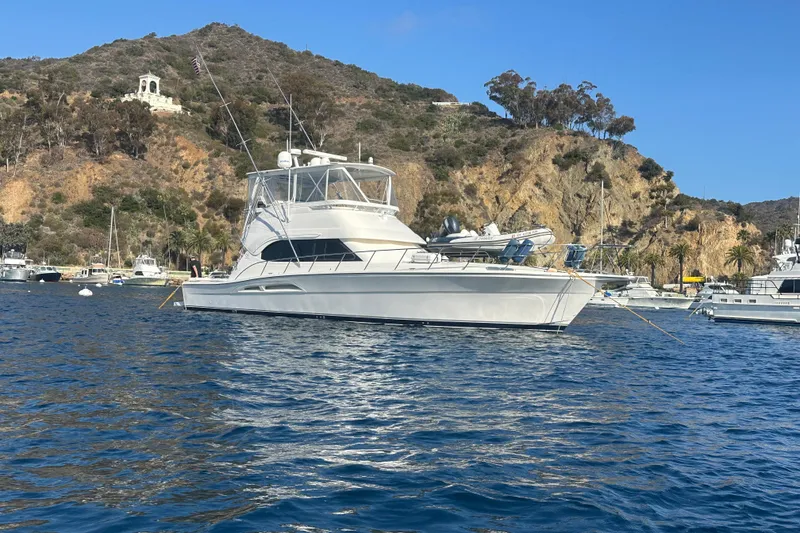 Slide: The Image of 2007 Riviera Sport Fisherman yacht anchored near scenic rocky coastline. - 1
