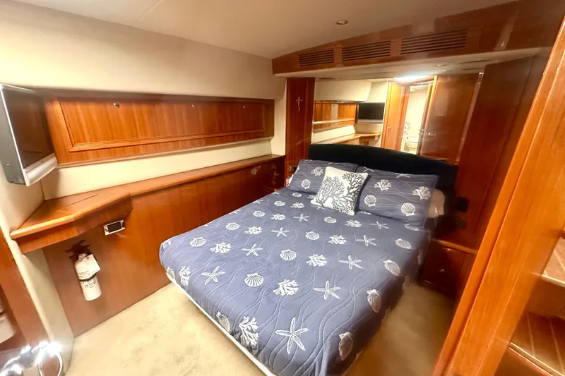 Slide: The Image of Luxurious 2007 Riviera Sport Fisherman cabin with elegant wood finishes and cozy bedding. - 14