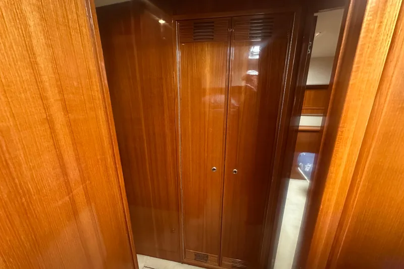 Slide: The Image of 2007 Riviera Sport Fisherman interior with polished wooden cabinetry and closet. - 18