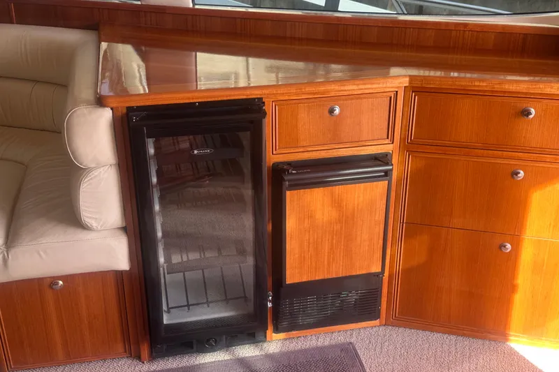 Slide: The Image of Interior of 2007 Riviera Sport Fisherman with wooden cabinetry and mini fridge. - 22