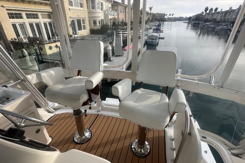 Slide: The Image of 2007 Riviera Sport Fisherman boat interior with white captain chairs and waterfront view. - 26
