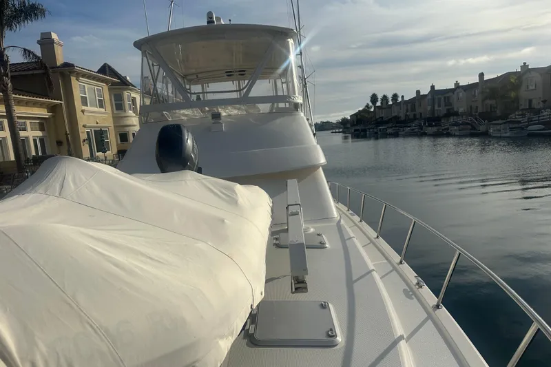 Slide: The Image of 2007 Riviera Sport Fisherman yacht docked by waterfront homes under a cloudy sky. - 31