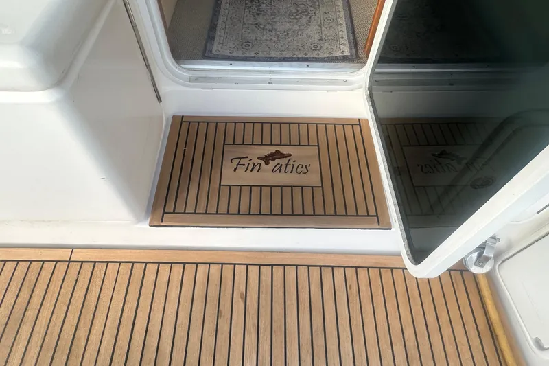 Slide: The Image of 2007 Riviera Sport Fisherman boat deck with wooden flooring and fishing equipment. - 45