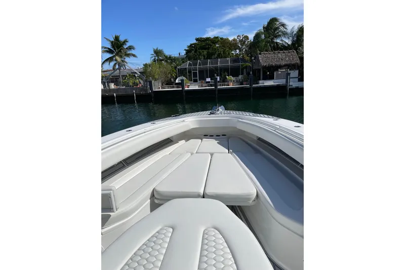 Slide: The Image of 2019 HCB 42 Siesta boat interior with white seating and tropical background. - 12