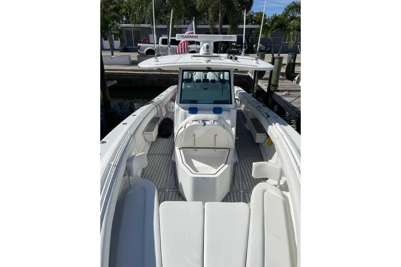 Slide: The Image of 2019 HCB 42 Siesta boat with cushioned seating, docked near palm trees. - 13