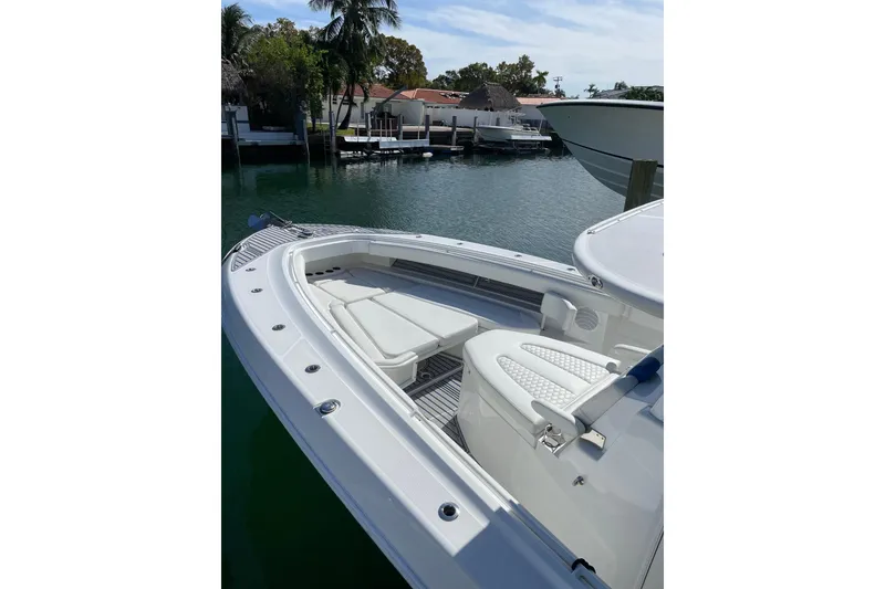 Slide: The Image of 2019 HCB 42 Siesta boat with white seating, docked near waterfront homes. - 16