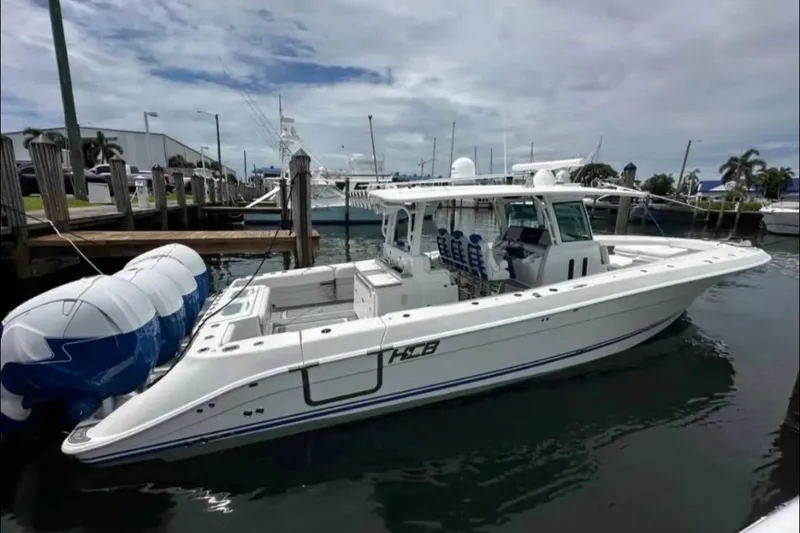 Slide: The Image of 2019 HCB 42 Siesta boat docked with four powerful outboard engines. - 2