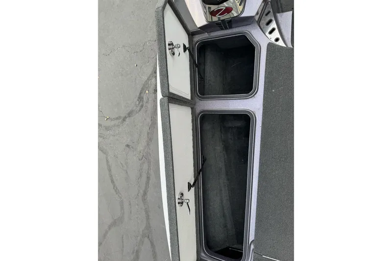 Slide: The Image of 2016 Ranger Z521 Comanche boat storage compartments open on a gray surface. - 14