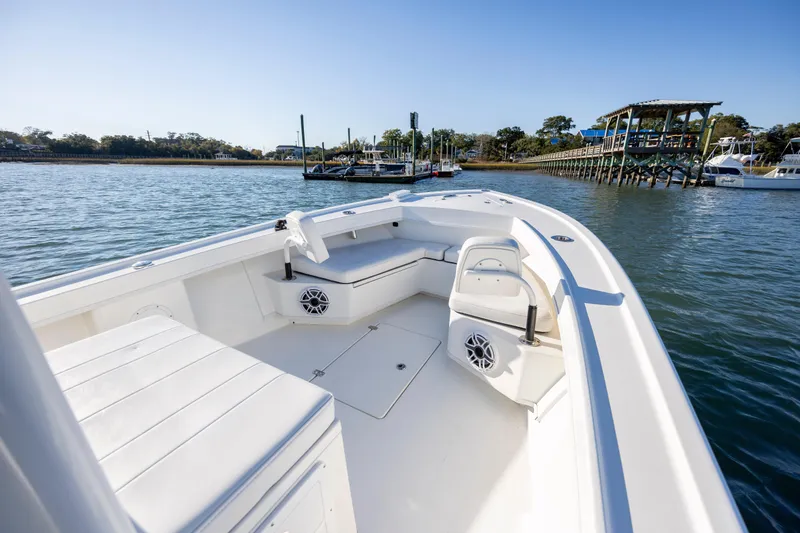 Slide: The Image of 2023 Pair Customs 24 Center Console DV boat on calm water near a dock. - 16
