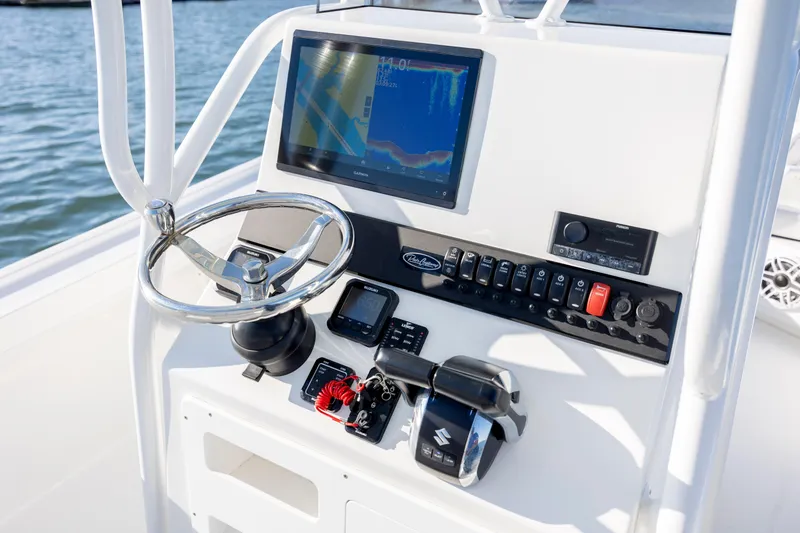 Slide: The Image of 2023 Pair Customs 24 Center Console DV boat dashboard with steering wheel and navigation controls. - 7