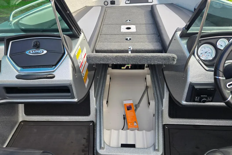 Slide: The Image of 2020 Lund 189 Tyee GL boat interior with storage compartment and dashboard view. - 15