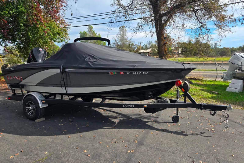Slide: The Image of 2020 Lund 189 Tyee GL boat with cover on trailer, parked outdoors. - 20