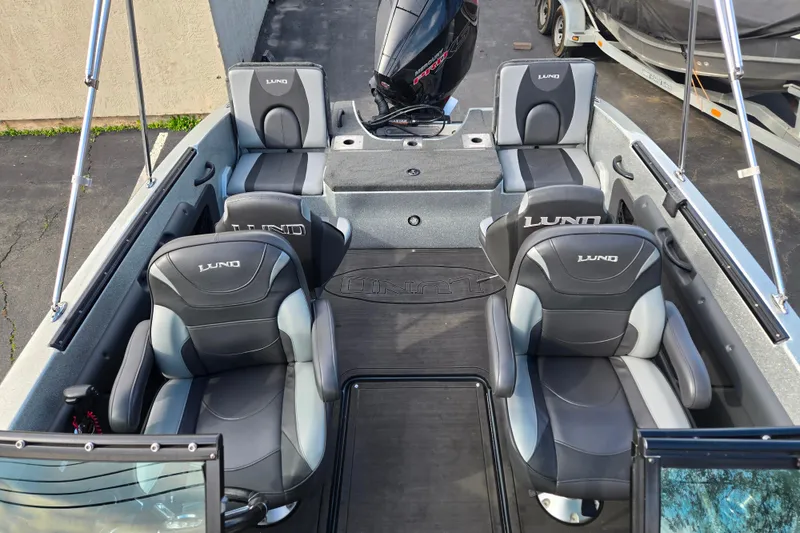 Slide: The Image of 2020 Lund 189 Tyee GL boat interior with four cushioned seats and motor. - 8