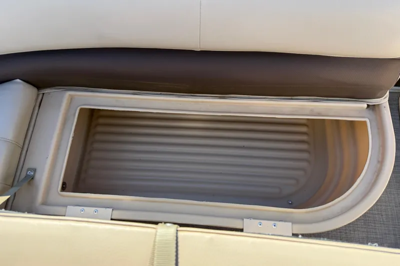 Slide: The Image of 2018 Sun Tracker Party Barge 18 DLX storage compartment with open seat cushion. - 30