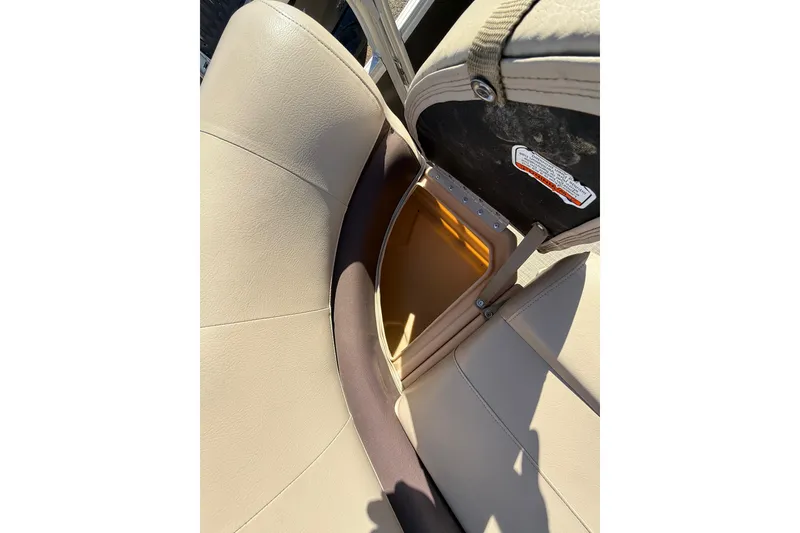 Slide: The Image of 2018 Sun Tracker Party Barge 18 DLX interior with helm and seating, docked by a lake. - 33