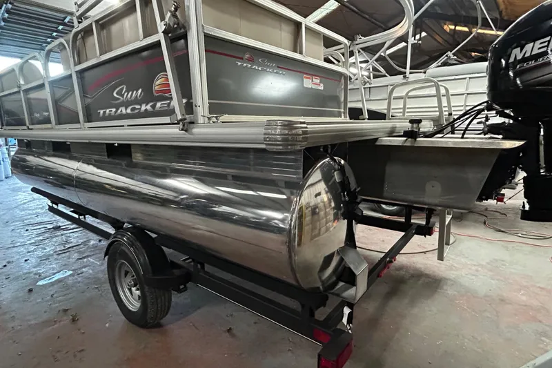 Slide: The Image of 2018 Sun Tracker Party Barge 18 DLX pontoon boat on trailer by the water. - 4