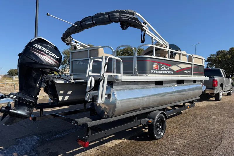 Slide: The Image of 2018 Sun Tracker Party Barge 18 DLX pontoon boat on trailer by a lake. - 48