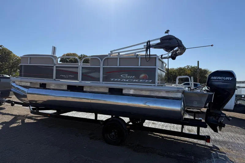 Slide: The Image of 2018 Sun Tracker Party Barge 18 DLX pontoon boat with beige seating on a calm lake. - 55