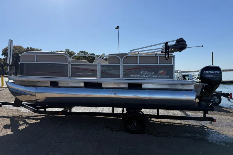 Slide: The Image of 2018 Sun Tracker Party Barge 18 DLX pontoon boat with beige seating on a calm lake. - 56