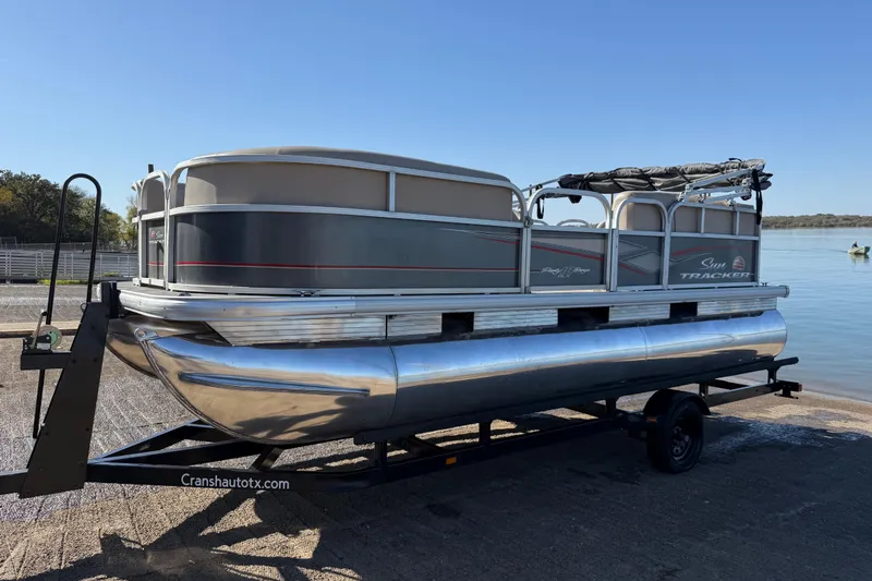 Slide: The Image of 2018 Sun Tracker Party Barge 18 DLX interior with steering console and seating on a lake. - 58